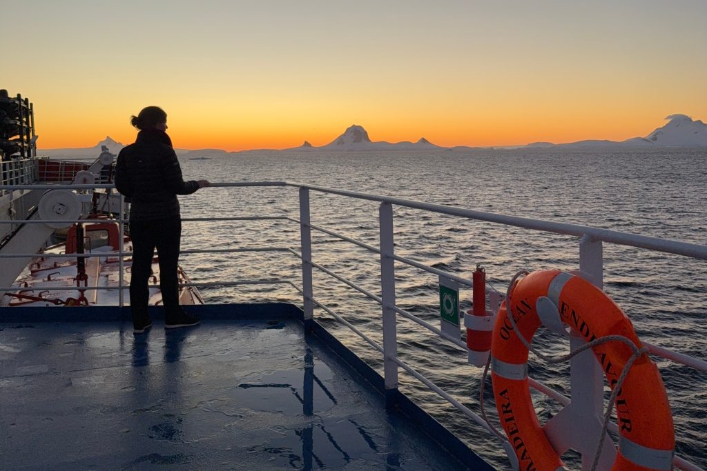 The author, Kaylyn K., admires the sunset from the top deck of the expedition ship Ocean Endeavour while visiting Antarctica in February 2025.