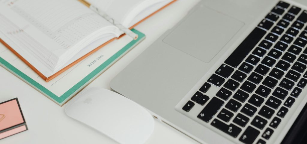 Image of laptop and notebook during custom travel itinerary planning: Photo by: Kaboompics.com