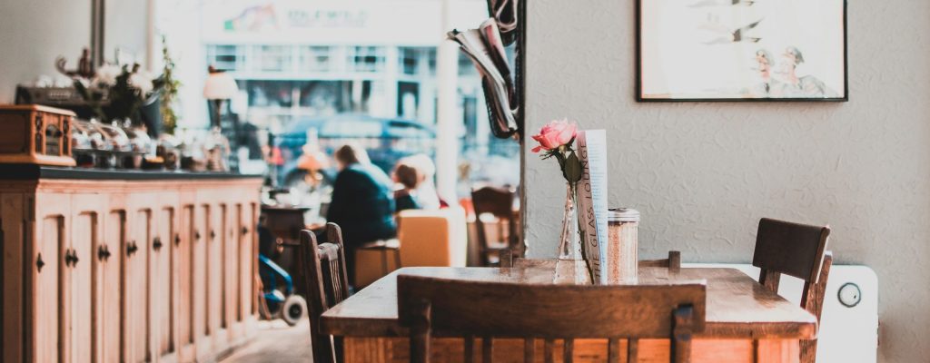 Photo of the interior of a cafe, with an empty table, from a staycation. Photo by Lisa from Pexels