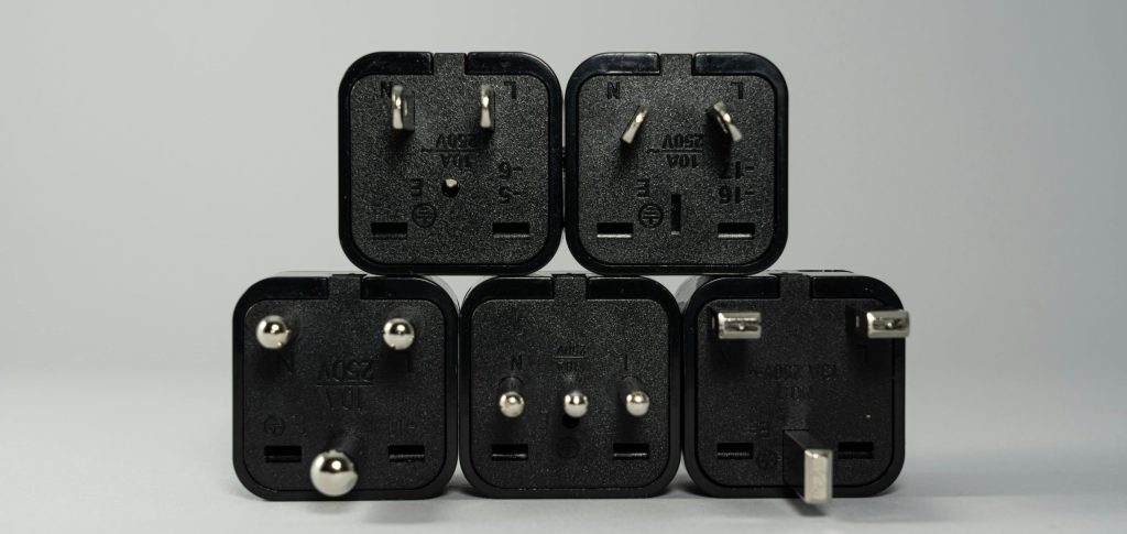 Photo of various prongs for outlets from different countries. Just another reason to make sure you have a travel adapter as part of your travel packing essentials list. Photo by Castorly Stock