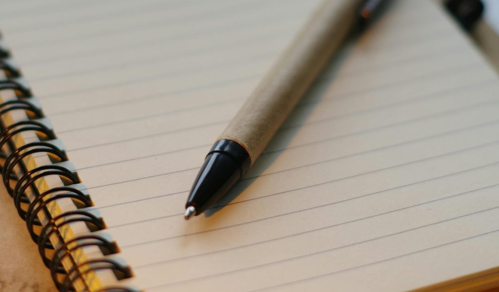 Pen and paper to create your pre-departure travel checklist. Photo by Manuel Cortés